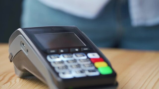 Contactless payment with smartphone. Wireless payment concept. Close-up, woman using smartphone cashless wallet NFC technology to pay order on bank terminal.