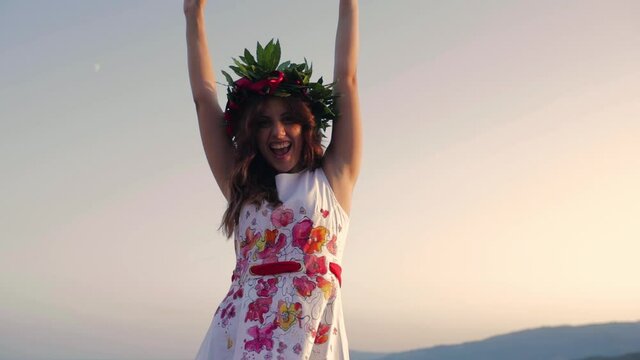 Giovane ragazza con vestito bianco si laurea. Corona di alloro in testa simbolo trionfale italiano.