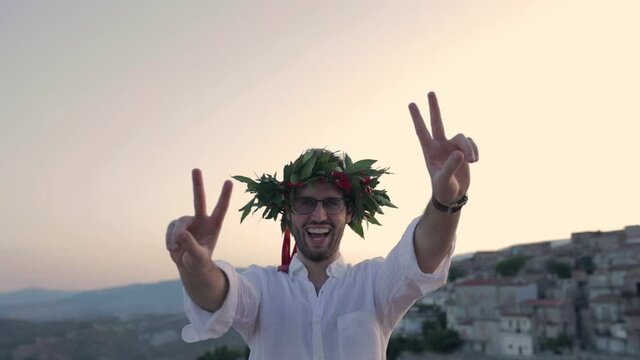 Ragazzo felice con corona di alloro per la laurea in Italia