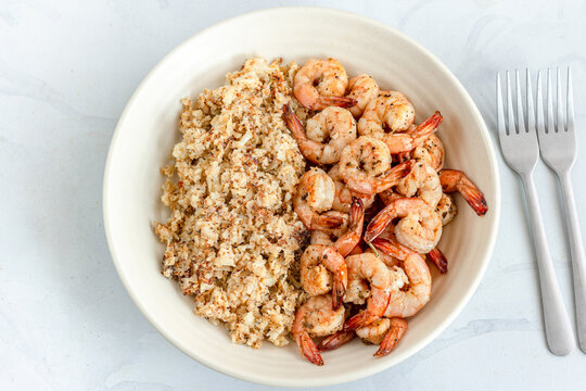 Cauliflower Rice And Sautéed Shrimp With Forks Directly Above Photo