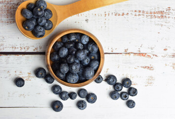 Blueberries on white wooden table and rustic utensils