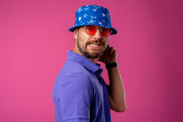 Funny bearded smiley man wearing beach hat and sunglasses