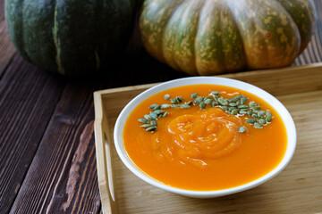 Creamy pumpkin soup on a wooden table