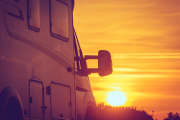 Camper vehicle on beach at sunrise