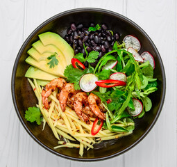 salad with avocado and shrimps in bowl, top view