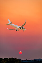 Commercial airplane flying above clouds in colorful sunset.Travel,holidays and business concept.