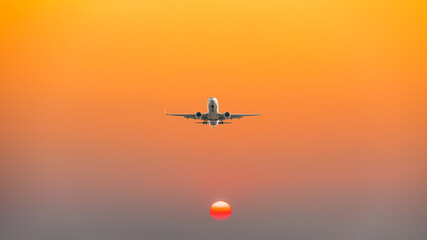 Commercial airplane flying above clouds in colorful sunset.Travel,holidays and business concept.