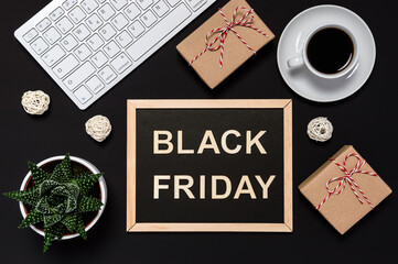 Black Friday sale. Presents, coffee, keyboard and blackboard with words in wooden letters on dark background. Online shopping concept. Flat lay style, desk top view