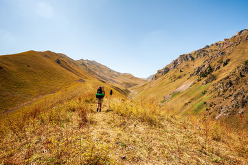 Group of young hikers trekking in mountains. Two women two men backpacking in summer near Sary...