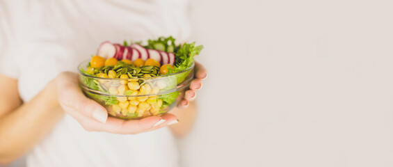 girl holding a glass bowl with vegan food