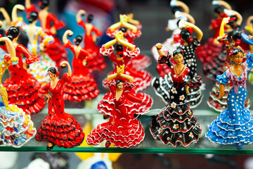 Ceramic mosaic and painted flamenco dancers figurines in colorful traditional dresses on showcase...