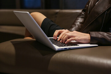 woman's hands are typing on laptop in the waiting room