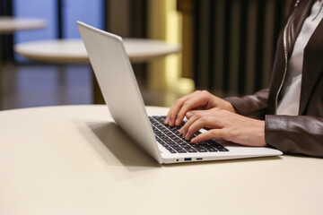 woman's hands are typing on laptop in the waiting room