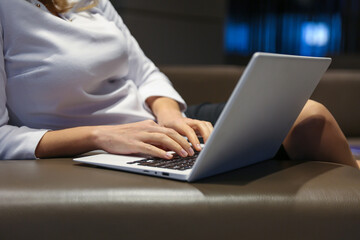 woman's hands are typing on laptop in the waiting room