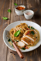 Chicken fillet with spinach and sun-dried tomatoes in coconut milk