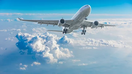 Verduisterende gordijnen Commercial airplane flying above blue sky and white clouds. © ABCDstock