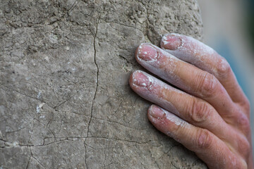 Adult male handholding on to a rock