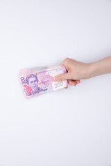 collection of hryvnia banknotes in female hand isolated on white background, close view