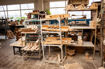 Parts of guitar hanging on the shelves at the factory
