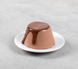 Creamy Italian dessert chocolate Panna cotta with sauce on a plate on a light background