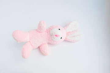 pink rabbit soft toy on a light solid background