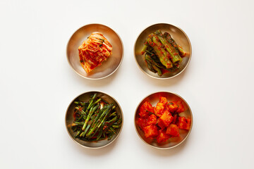 The most famous Korean food Kimchi (napa cabbage, leaf mustard, turnip, leek) in high quality brass tableware. Isolated on white background. Top view. 
