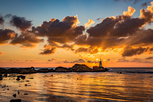 Scenery amazing sunrise at Ahtopol lighthouse, Black Sea, Southeastern Bulgaria. Beautiful clouds and vivid colors in the picture, copy space available. October travel photo.