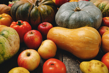 Pumpkins and red apples on wooden background