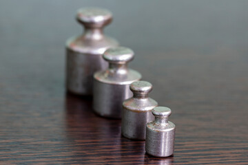 A set of old scratched iron weights for a pharmacy scale.