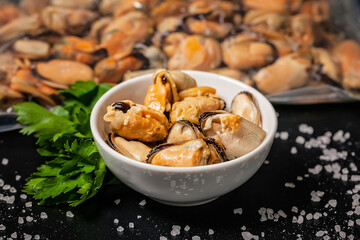 Delicious mussel meat. Seafood with fresh parsley on a dark background. Close-up