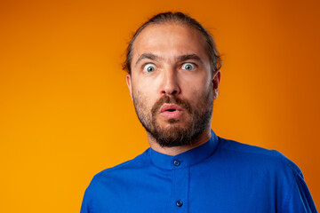 Amazed and confused bearded man looks with astonishment