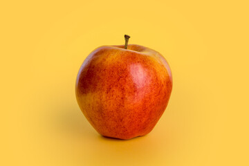 apple isolated on yellow background, autumn red fruit of the variety called royal gala