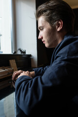 Fototapeta premium portrait of a young man sitting at the table. man in a jacket and a T-shirt