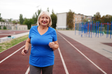 Beautiful adult woman running outdoors on the stadium