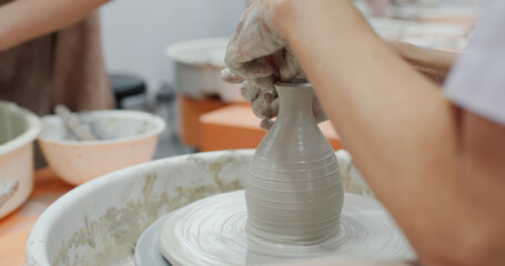 Hand work on pottery wheel, shaping a clay pot