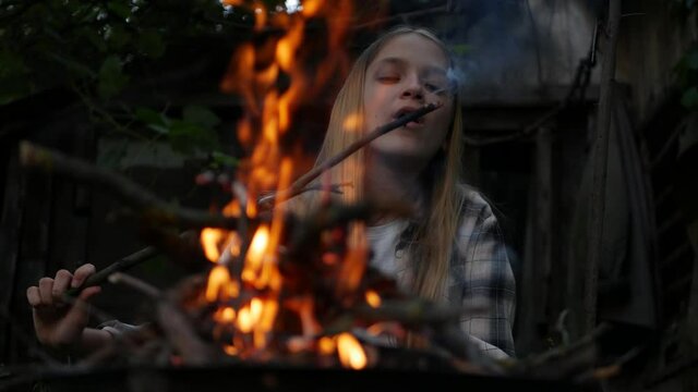 Kid Playing at Campfire Adventure Outdoor in Night, Child Plays with Fire in Camp, Girl in Nature at Countryside, Rustic in Dark