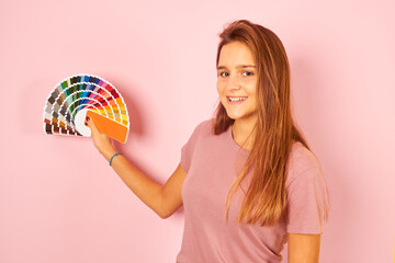 interior designer woman holding a color guide palette isolated on yellow background