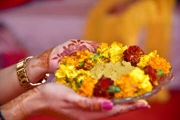 Traditional Haldi turmeric kept on a flower plate for the hindu marriage ceremony.