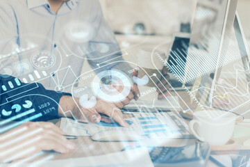 Technology theme hologram with man working on computer on background. High tech concept. Multi exposure.