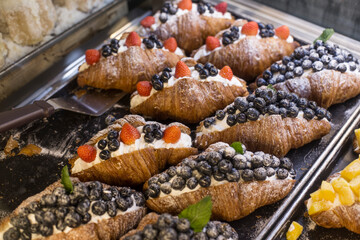 croissants, cream and fresh fruit on a tray.