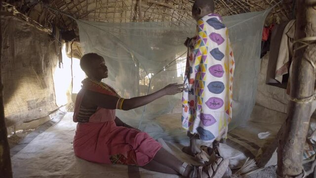 Child using mosquito net in bed to prevent malaria infection. Kenya. Africa.