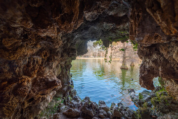 Small lake in Buen Retiro park seen through a cave