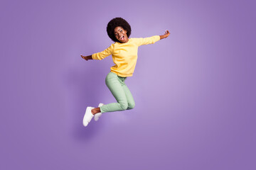 Fototapeta na wymiar Full body photo of crazy afro american girl jump hold hands plane flying game concept isolated on violet color background