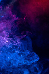 Conceptual image of colorful red and blue color smoke on dark black background.
