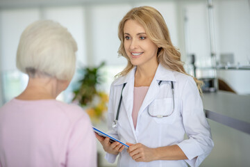 Senior woman talking with the doctor in the clinic