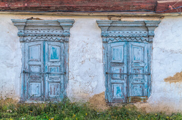 Old wooden windows of an ancient rustic adobe house