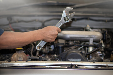 The mechanic is checking the engine.
