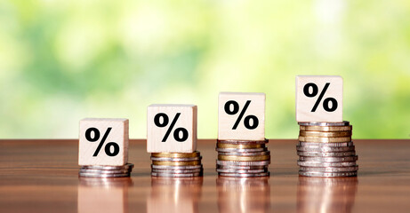Percentage sign on wooden cube block with growth step coin. Financial