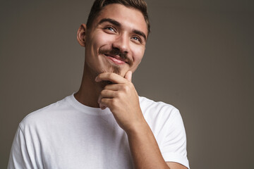 Image of joyful unshaven guy smiling and looking upward
