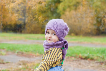 A child in a purple, knitted hat and scarf.